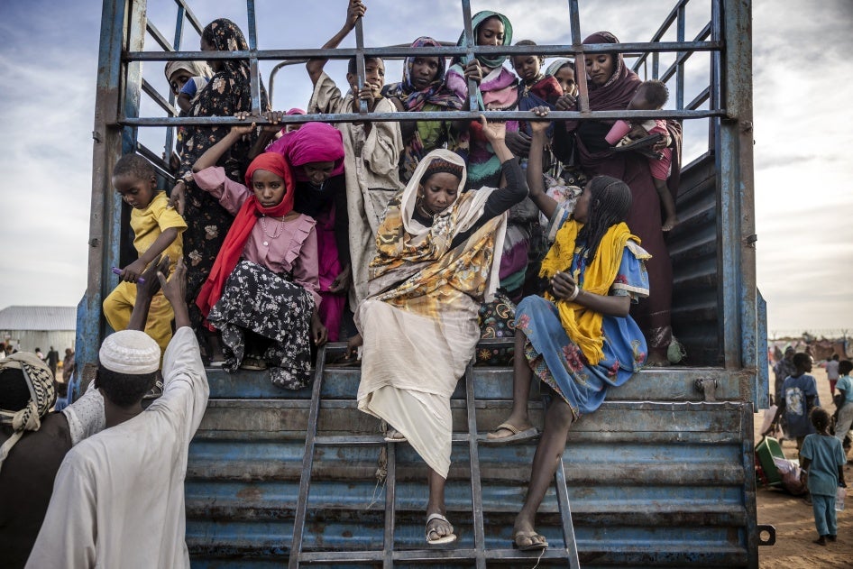 Sudanesische Geflüchtete steigen am 13. Februar 2024 aus einem mit Familien vollgepackten Lastwagen, der in einem Transitzentrum für Geflüchtete in Renk, Südsudan, ankommt.