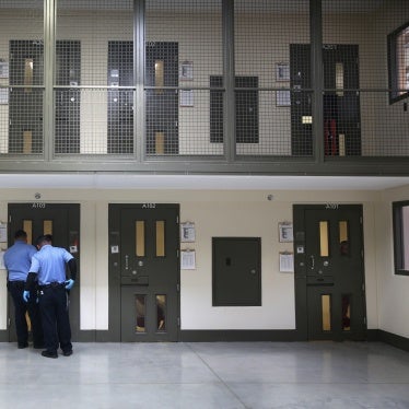 Guards prepare to escort an immigrant detainee from his 'segregation cell' back into the general population at the Adelanto Detention Facility, Adelanto, California, on November 15, 2013.